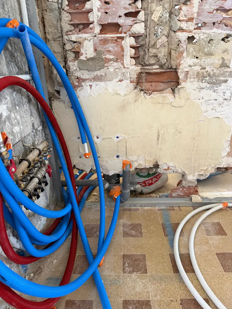 Nourrice laiton et faisceaux PER bleu et rouge tirés sous gaine pour une rénovation de salle de bain