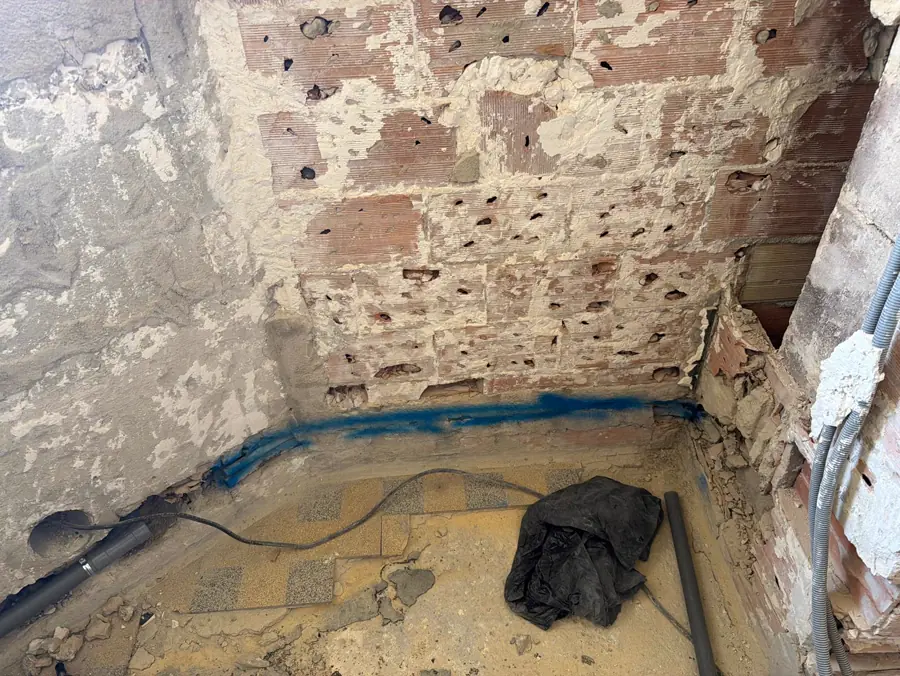Saignée réalisée en pied de mur pour le passage d'une évacuation en PVC